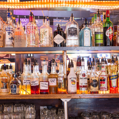 liquor bottles in front of a mirror behind  the bar at Mad Hanna