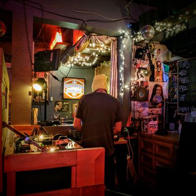 A DJ preforming in the DJ booth, known as the Cat Box, at Mad Hanna