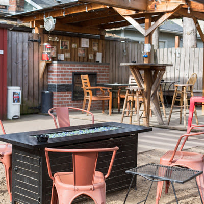 Patio with gas fire pit, table and chairs as well as an electric fireplace