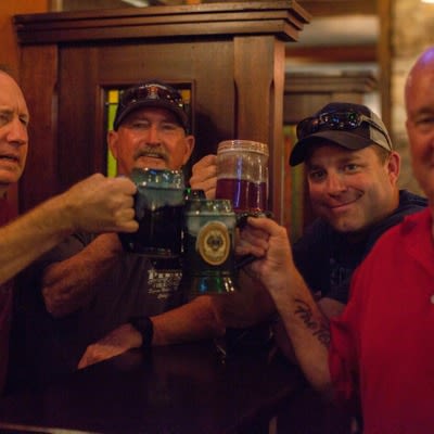 Customers cheering and posing with beer steins
