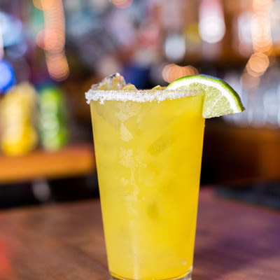 a fresh squeezed margarita with a salt rim and a lime wedge