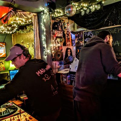 Two DJs preforming in the DJ booth, known as the Cat Box, at Mad Hanna
