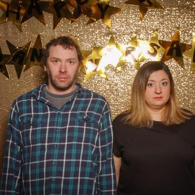 Two guesting posing for a photo, looking confused