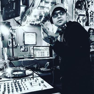 A DJ preforming in the DJ booth, known as the Cat Box, at Mad Hanna