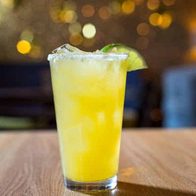 a fresh squeezed margarita with a salt rim and a lime wedge
