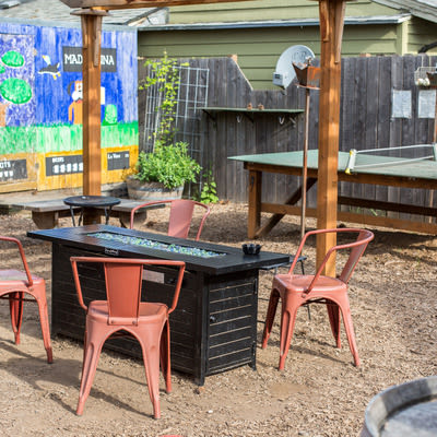Mad Hanna patio with ping pong table, gas fire pit, and Duck Hunt inspired mural in background