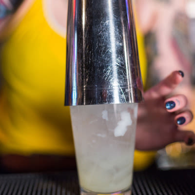 A tumbler crowning a pint glass preparing to shake a cocktail.