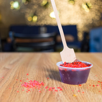 a cherry jello shot garnished with cherry pop rocks