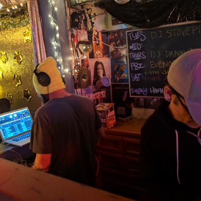 2 DJs preforming in the DJ booth, known as the Cat Box, at Mad Hanna