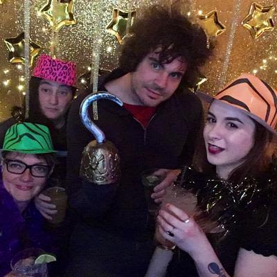 Four guests, three with hats and one with a hook posing