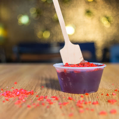 a cherry jello shot garnished with cherry pop rocks