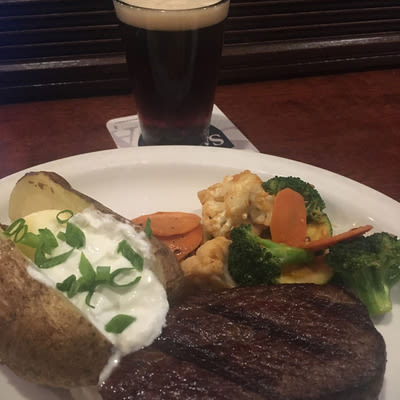 A served steak with baked potato and vegetables