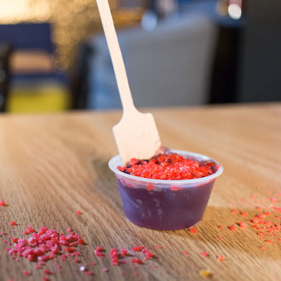 a cherry jello shot garnished with cherry pop rocks