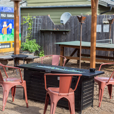 Mad Hanna patio with ping pong table, gas fire pit, and Duck Hunt inspired mural in background