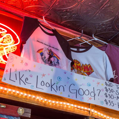 Mad Hanna apparel for sale with a sign that asks: 