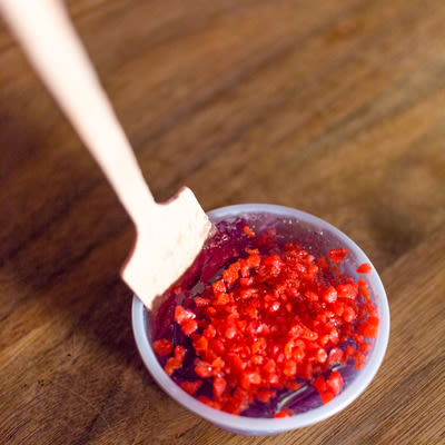 a cherry jello shot garnished with cherry pop rocks