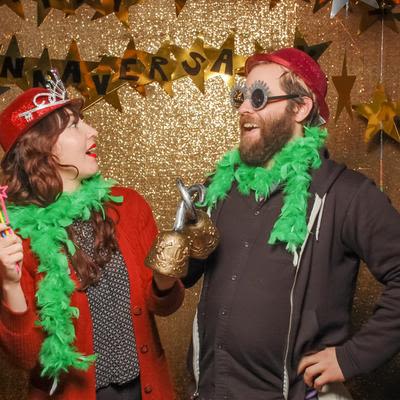 A couple wearing funny hats, glasses and hooks